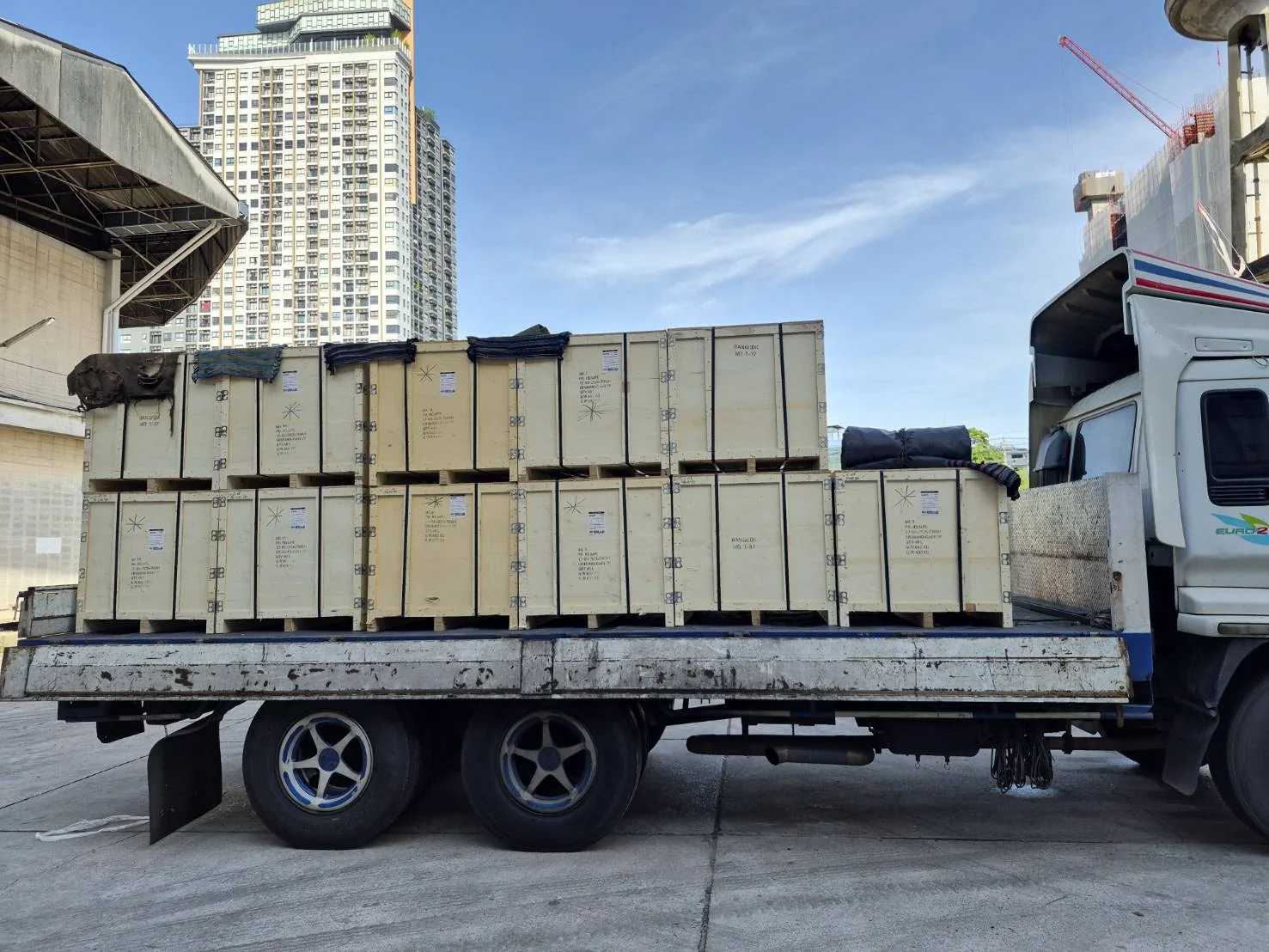 Forklift unloading heavy industrial chain crates from flatbed truck at MPC Bangkok warehouse